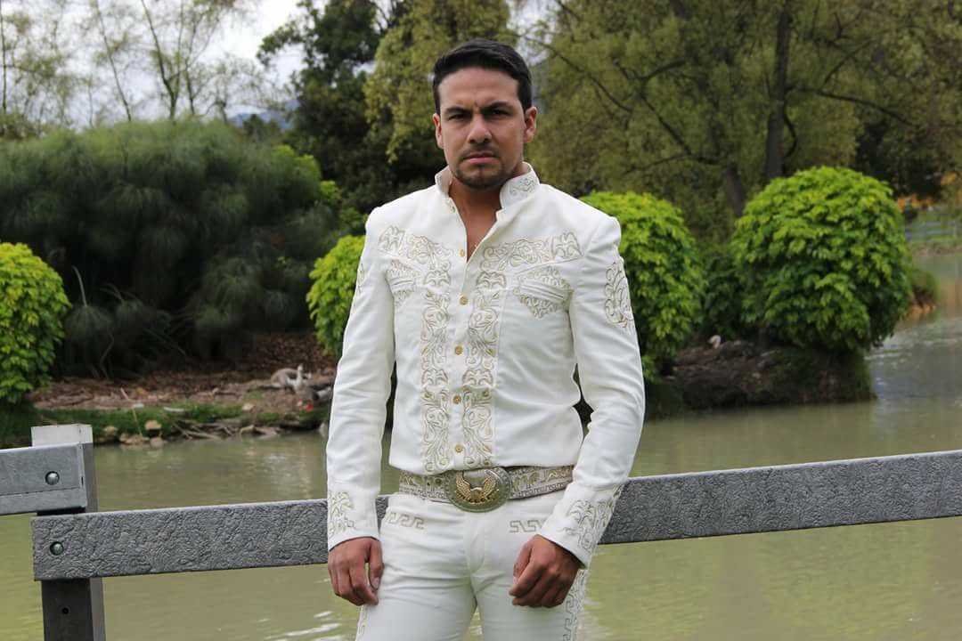 Mariachi de Bogotá con traje de charro blanco bordado, listo para salir a cantar